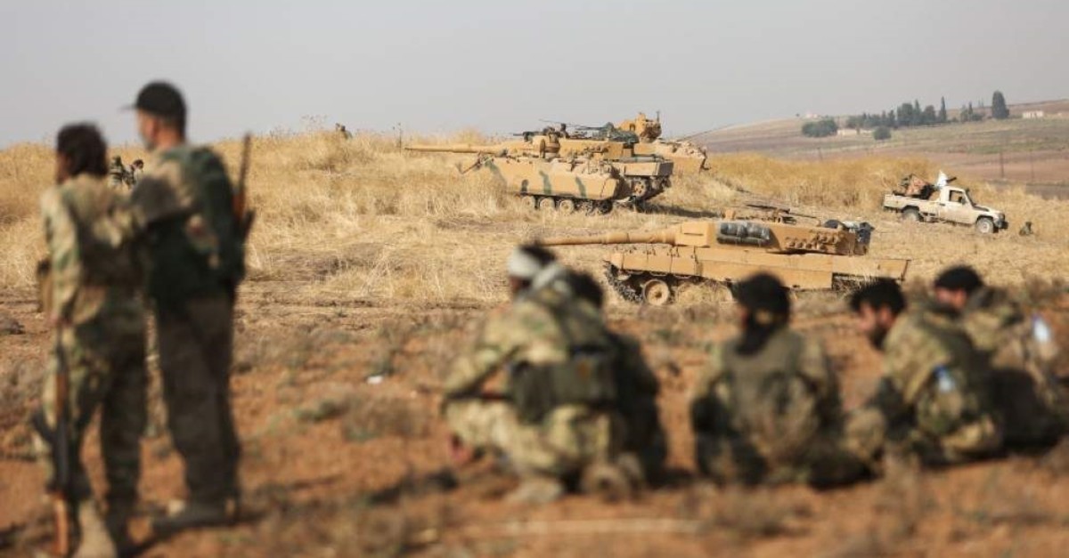 Turkey-backed Syrian fighters gather near Turkish tanks at a position east of the northeastern Syrian town of Ras al-Ayn on Oct. 28, 2019. (AFP Photo)
