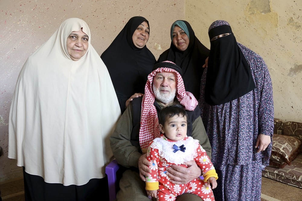 From left to right (standing): Bassama Abu Massoud,72; her daughter Hanaa,50; Hanaau2019s daughter,Abir,33; Abiru2019s daughter, Ala,18. Patriarch Abdullah Abu Massoud,77, sits in a chair, holding his 9-month-old great-great-granddaughter, Tuqaa, in his lap.