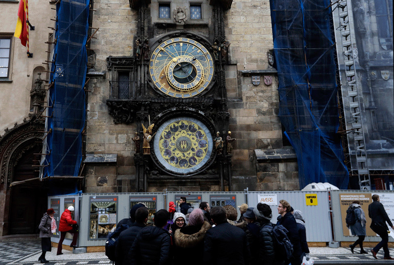Tourists stand in front of the famed astronomical clock at the Old Town Square in Prague, Czech Republic, Monday, Jan. 8, 2018 (AP Photo)