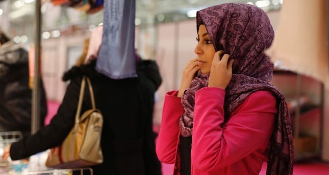 A visitor trying on a hijab at the Annual Meeting of France's Muslims in 2015, north of Paris.