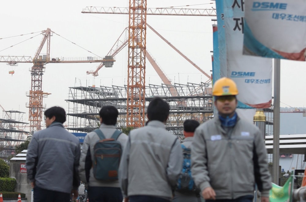 Employees of Daewoo Shipbuilding & Marine Engineering walk in a shipyard in Geoje, South Korea.