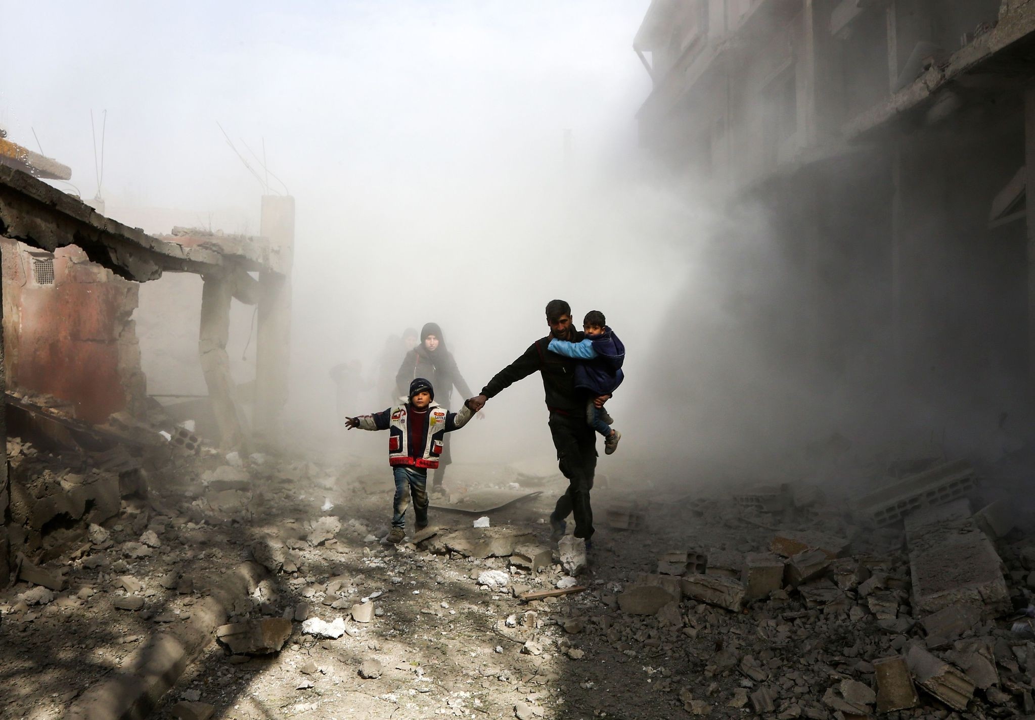 Syrian civlians flee from reported regime air strikes in the rebel-held town of Jisreen, in the besieged Eastern Ghouta region on the outskirts of the capital Damascus, on February 8, 2018. (AFP Photo)