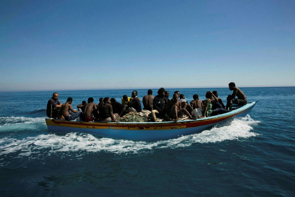 Migrants travel in a boat after they were rescued by the Libyan coast guard in the Mediterranean off the Libyan coast in Guarabouli, July 8.