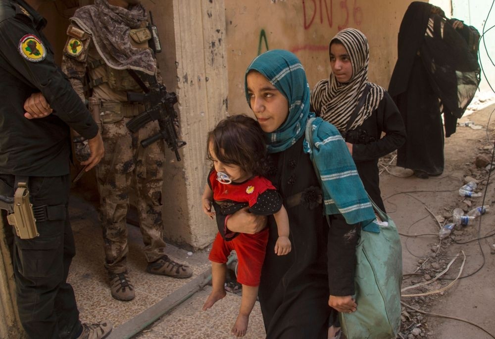 Civilians flee as members of Iraq's Counter-Terrorism Service (CTS) advance in the old city of Mosul yesterday, amid an' ongoing government offensive to retake the city from Daesh.