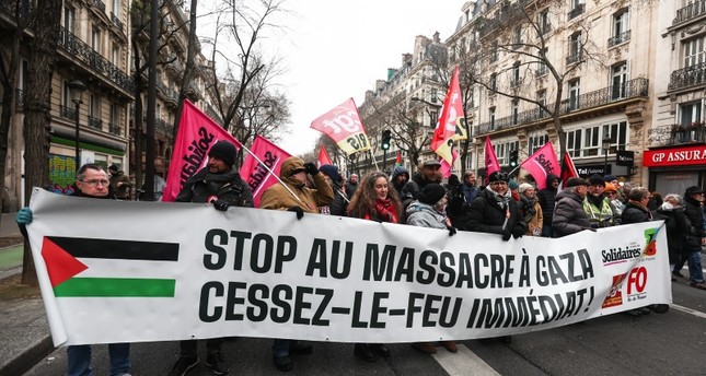 متظاهرون يحملون لافتة كتب عليها أوقفوا المذبحة في غزة، وقف إطلاق النار فورًا في مظاهرة تضامنية مع الشعب الفلسطيني، باريس، فرنسا، 13 يناير 2024 الفرنسية
