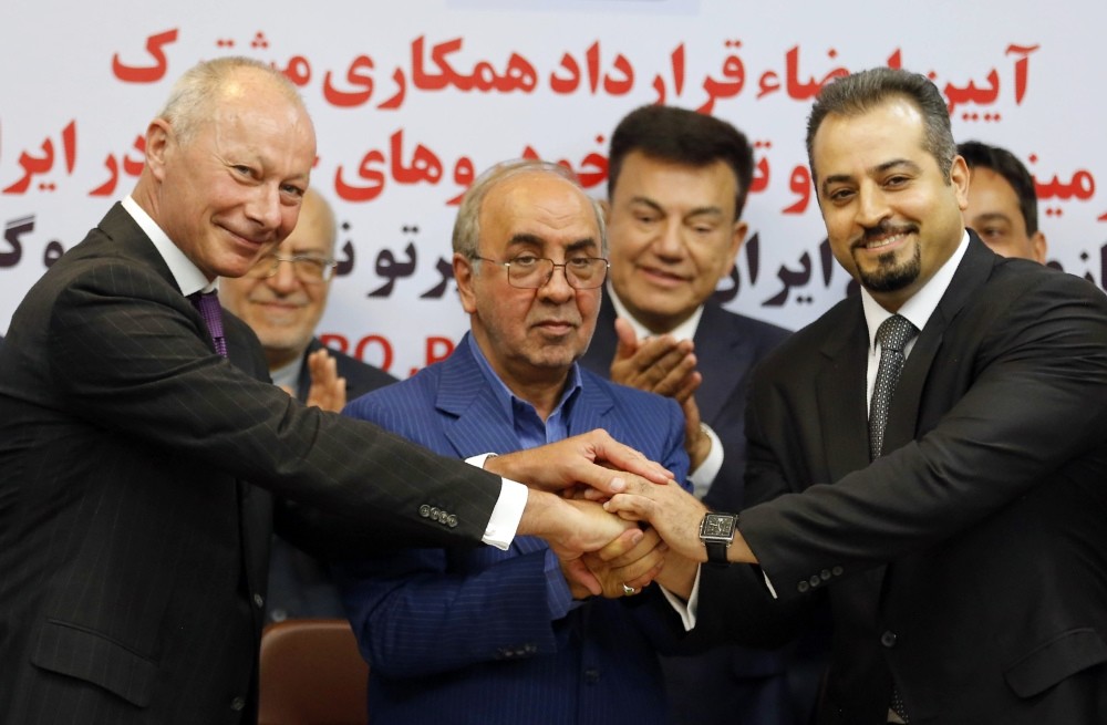 (L to R) Bollore, deputy director of competitiveness at Renault, Moazami, chairman of the board of directors of the IDRO Group, and  Solouk, deputy director of the Iranian Automobile Importers Association, shake hands in Tehran Monday.