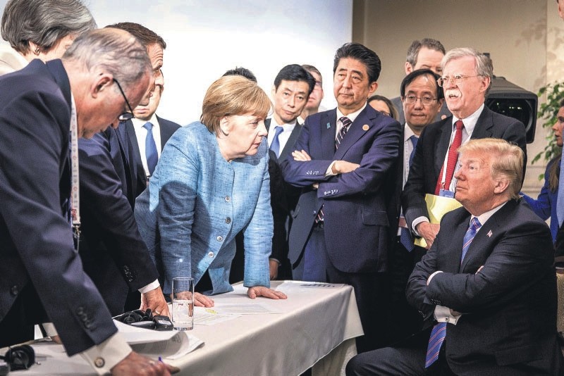 German Chancellor Angela Merkel (C) speaks with to U.S. President Donald Trump (R) on the second day of the G-7 meeting in Charlevoix, Canada, June 9.