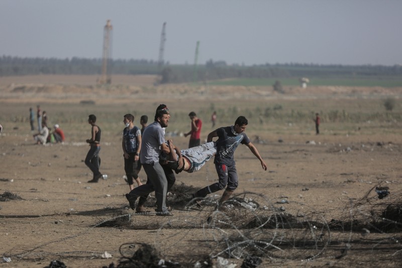 Palestinians protesters carry a wounded protester in clashes during a Friday protest near the border in the east of Khan Younis town southern Gaza Strip on, 08 June 2018. (EPA Photo)