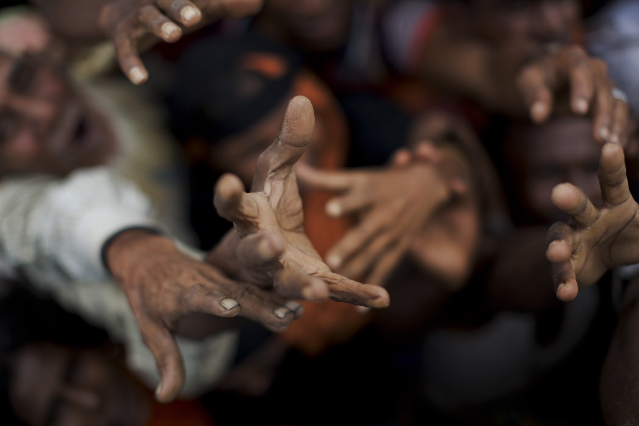 Newly arrived Rohingya stretch out their hands to receive puffed rice food rations donated by local volunteers in Kutupalong, Bangladesh, Sept. 9, 2017. (AP Photo)