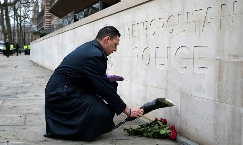 A member of the public lays flowers outside New Scotland Yard in central London, Britain, March 23.