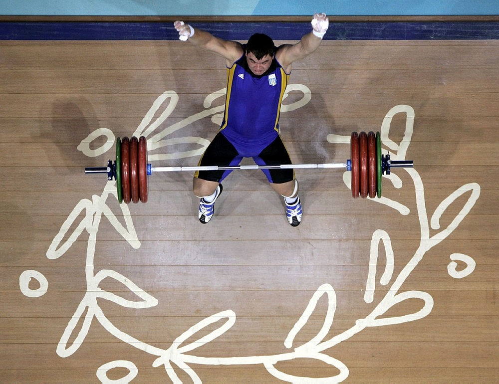 Oleksiy Kolokoltsev of the Ukraine falls backwards after failing at his attempt to lift 430 pounds (195 kg during the 2004 Summer Olympics in Athens, Wednesday Aug. 25, 2004. (AP Photo)
