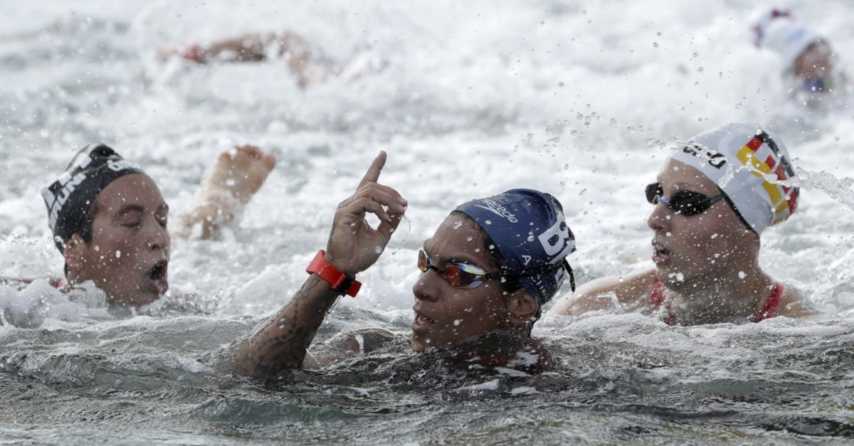 Ana Marcela Cunha of Brazil, center, reacts after finishing the race in Yeosu, South Korea, July 17, 2019.