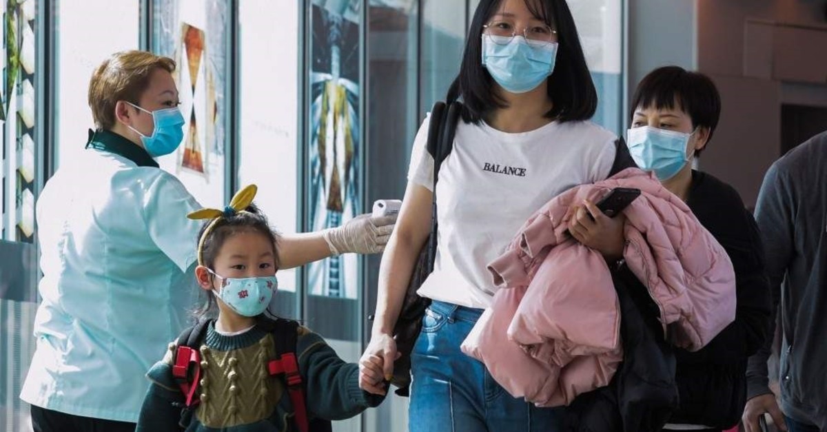 A health officer (L) screens arriving passengers from China at Changi international airport, Singapore, Jan. 22, 2020. (AFP Photo)
