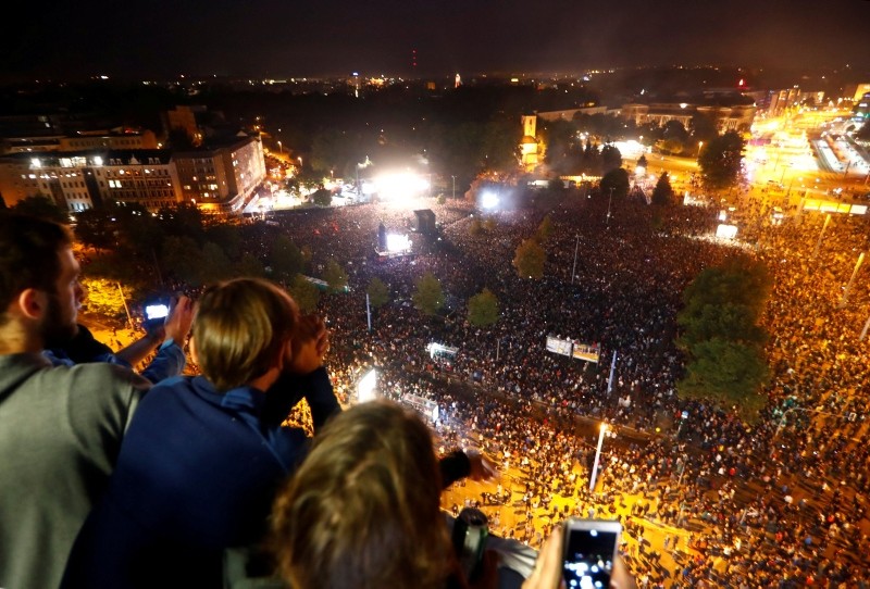 People watch an open air 