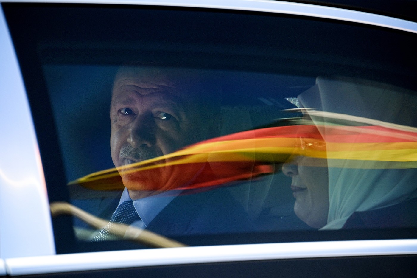 President Recep Tayyip Erdoğan sits in a car behind a reflection of the German flag as he departs after his arrival from the Berlin Tegel Airport for an official visit in Berlin, Germany, 27 September 2018. (EPA Photo) 