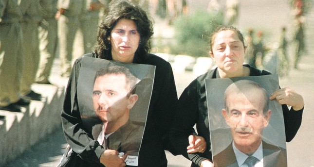 نساء يحملن صور حافظ الأسد وابنه بشار في جنازة الأول رويترز