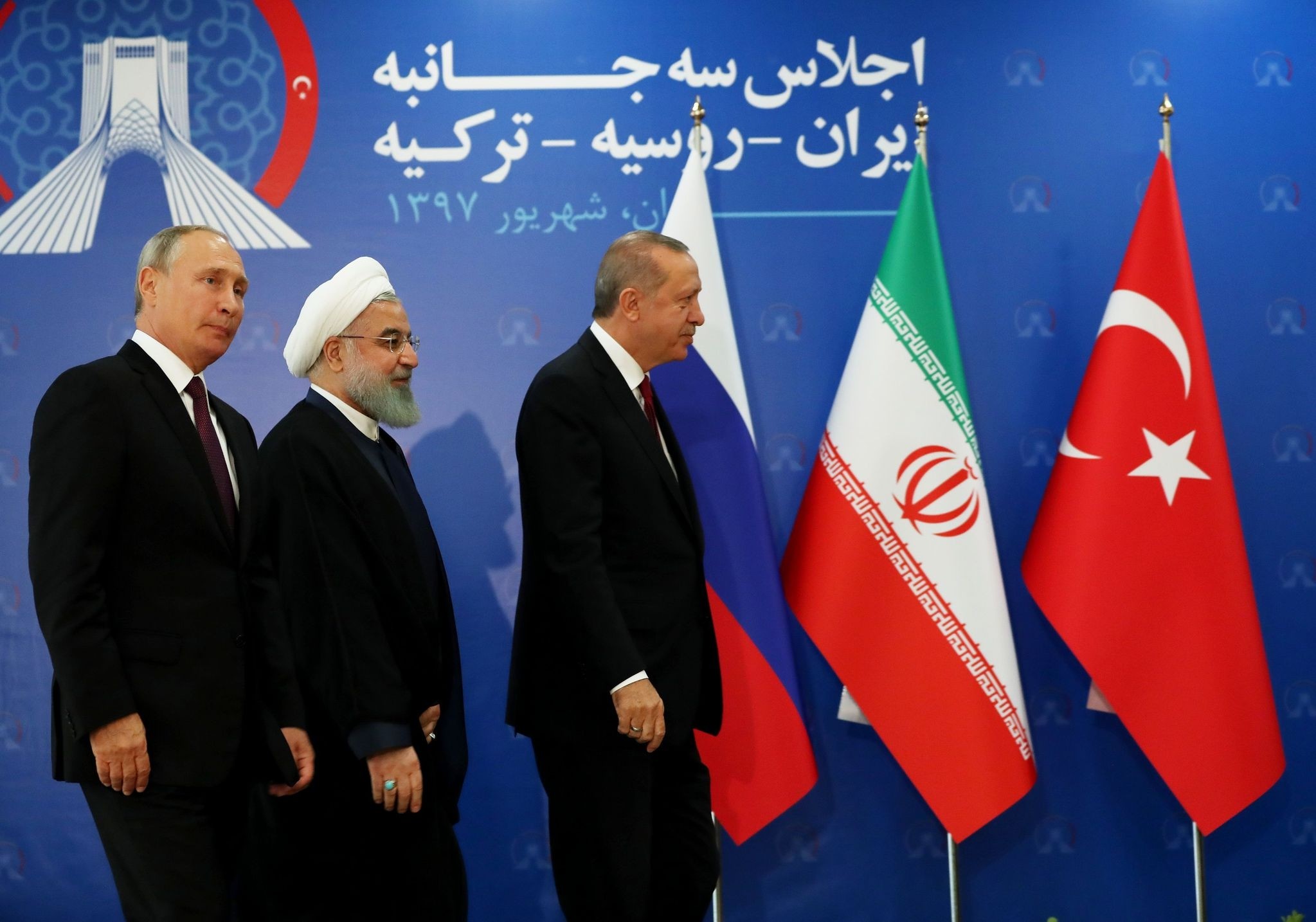 President Recep Tayyip Erdou011fan (R), Iranian President Hassan Rouhani (C) and Russian President Vladimir Putin (L) prepare to leave the stage during the trilateral summit on the Idlib crisis, Tehran, Sept. 7.