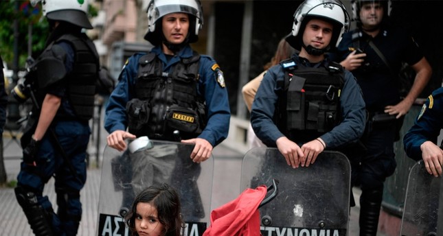 عناصر من الشرطة اليونانية أمام مظاهرة لطالبي اللجوء أمام مكاتب الاتحاد الأوروبي الفرنسية