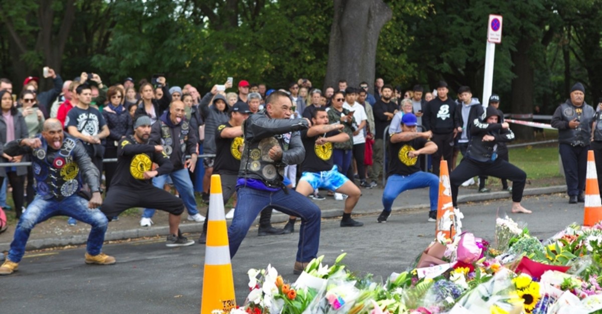 Various community group members performing the Maori ceremonial dance, the Haka, in the street, next to floral tributes for victims of mosque attacks on Sunday, March 17. (AA Photo)