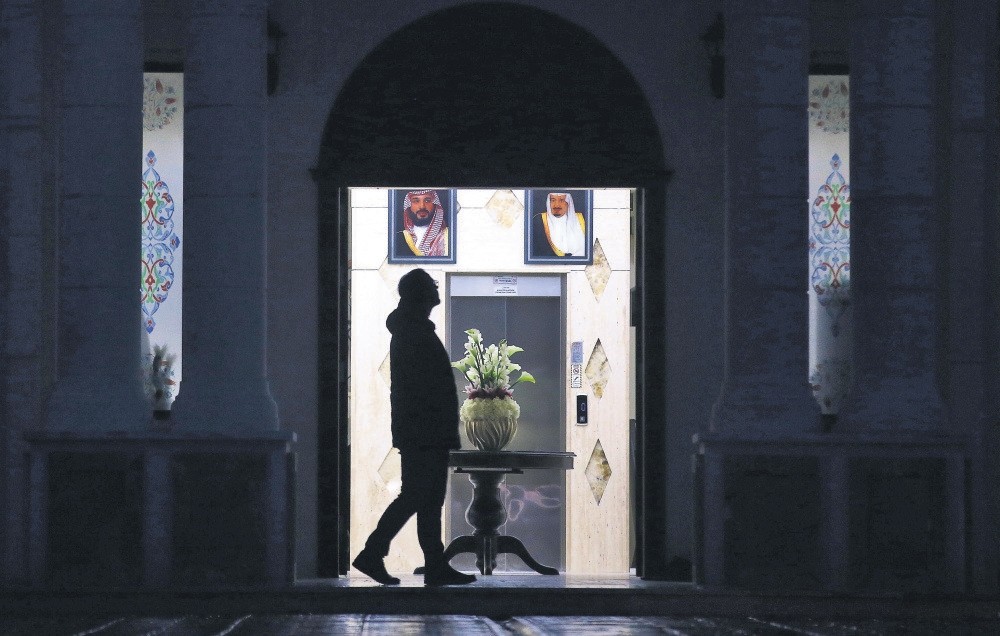 A Turkish forensic officer walks in front of the pictures of Saudi Crown Prince Mohammed Bin Salman (L) and Saudi King Salman (R) during an investigation at a villa in Yalova city, Turkey, Nov. 26.