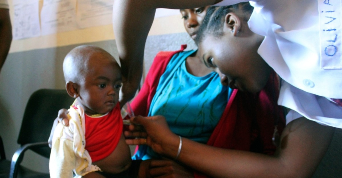 In this photo taken on Thursday, March 21, 2019, a volunteer nurse examines 6-moth-old Sarobidy, who is infected with measles, while her mother Nifaliana Razaijafisoa looks on, at a healthcare centre in Larintsena, Madagascar. (AP Photo)
