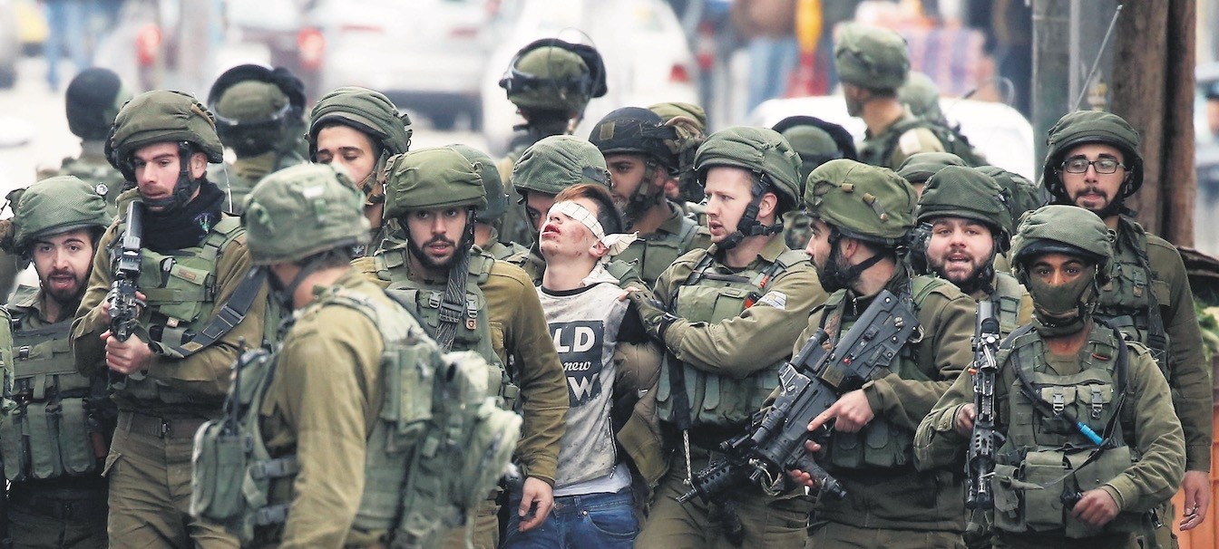 2017u2019s most symbolic photo is that of Fawzi al-Juneidi, the 16-year-old Palestinian boy, being detained by Israeli soldiers after his protests against Trump's decision on Jerusalem and Israeli state's occupation in his land, the West Bank, Dec. 7. 
