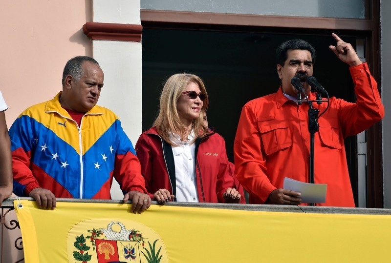 Venezuela's President Nicolas Maduro (R), speaks to a crowd of supporters flanked by his wife Cilia Flores (C) and the head of Venezuela's Constituent Assembly Diosdado Cabello,  during a gathering in Caracas on January 23, 2019. (AFP Photo)