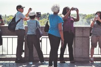 Tourists take photos of the surrounding, ignoring the human connection around them.