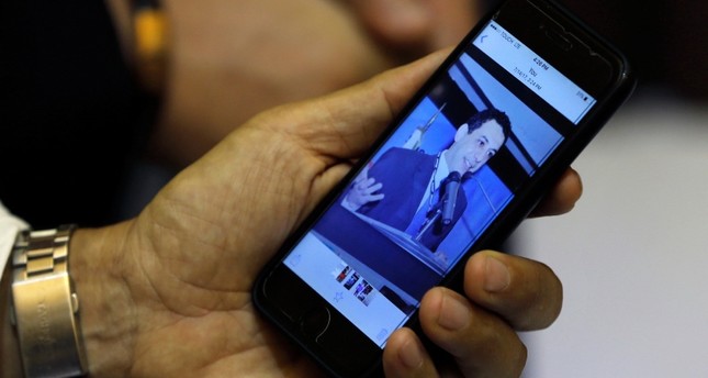 زياد زكا شقيق نزار زكا المسجون في إيران، يظهر صورة لأخيه على هاتفه الخلوي AP