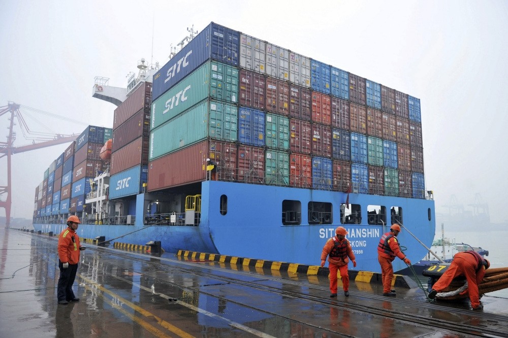 Workers moor a container ship at a port in Qingdao in east China's Shandong province, Jan. 11, 2019.